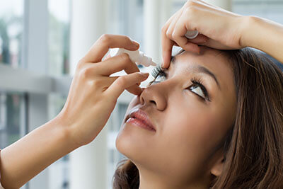 Woman Putting Eye Drops in Her Eye